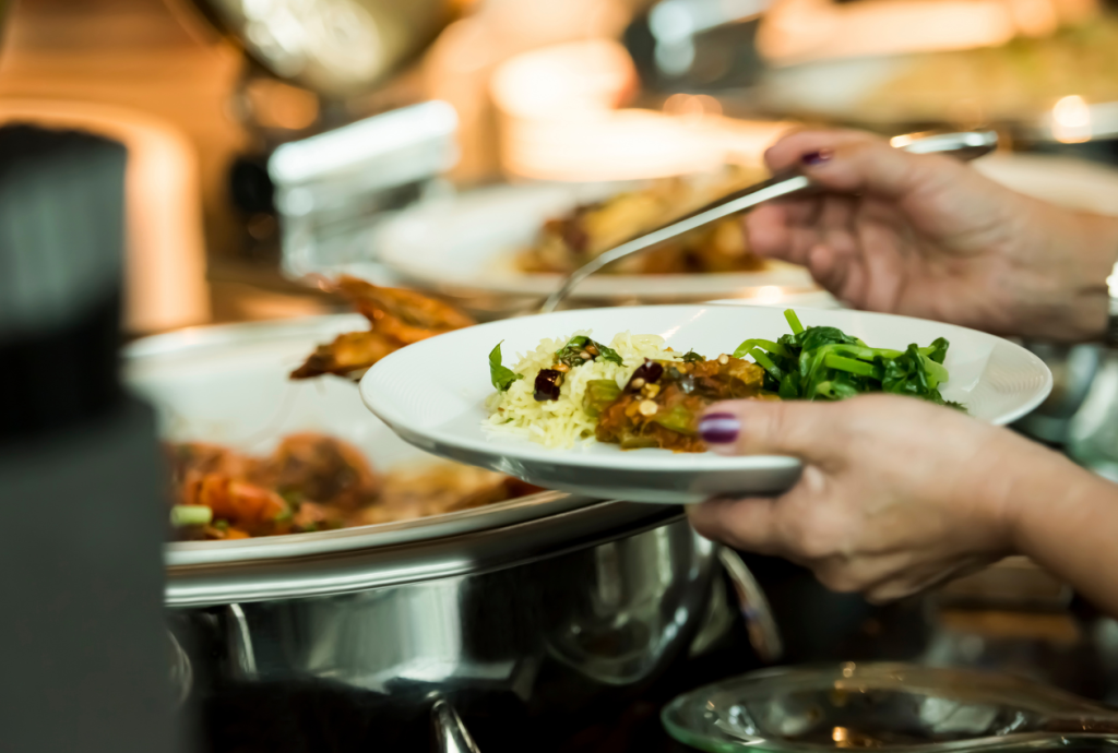 Man tar mat från serveringsdisk.